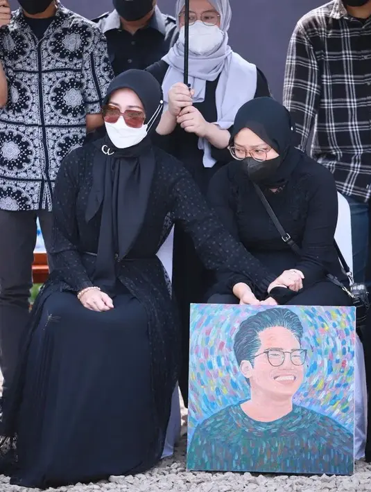 Camillia Laetitia Azzahra atau Zara saat memegang lukisan wajah Eril yang tersenyum saat jenazah Emmeril Kahn Mumtadz atau Eril dimakamkan. Eril telah dimakamkan di pemakaman keluarga di Cumaung, Kabupaten Bandung, Jawa Barat pada Senin (13/6/2022). (Instagram/ataliapr)