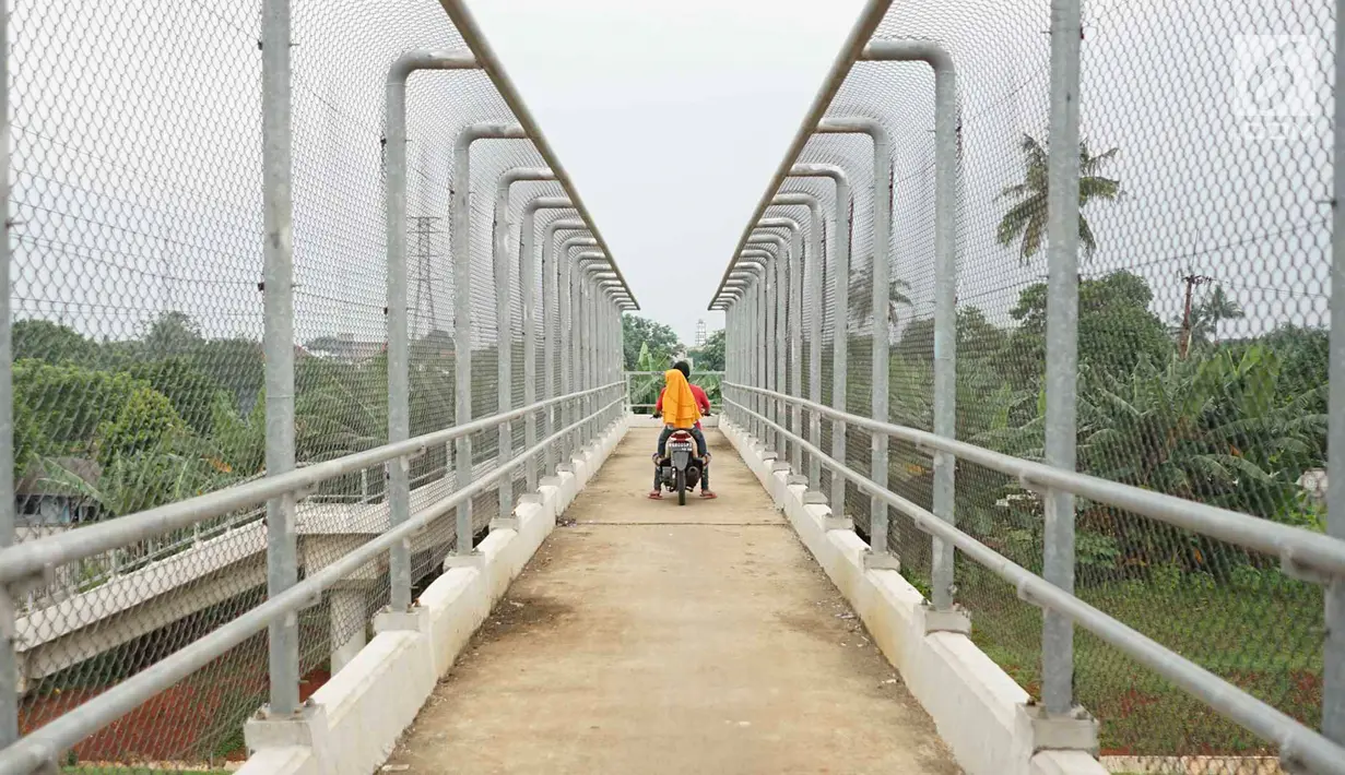 Pengendara sepeda motor melintasi JPO yang melintang di atas Tol Cijago Seksi II di Depok, Jawa Barat, Rabu (15/5). Meskipun berbahaya, namun curamnya akses JPO tidak menjadi penghalang bagi sebagian pemotor untuk menyeberang agar dapat memersingkat waktu tempuh. (Liputan6.com/immanuel Antonius)