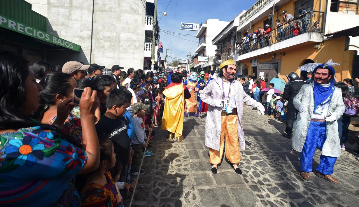 Anggota Saturno Club mengenakan kostum selama berpatispasi dalam parade Dance of Costumes tahunan di sepanjang jalan kota Sumpango, Guatemala, Senin (30/12/2019). Parade kostum yang menampilkan karakter televisi dan film ini untuk memeriahkan malam pergantian tahun. (ORLANDO ESTRADA/AFP)
