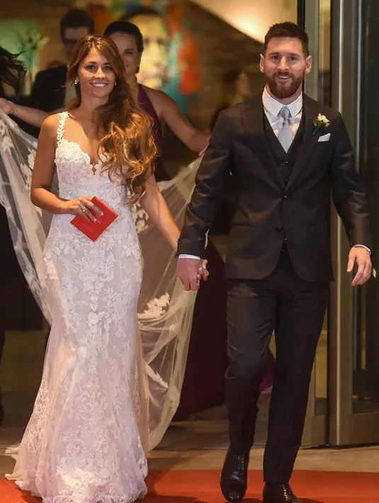 Bintang sepak bola, Lionel Messi berjalan di karpet merah bersama istrinya Antonella Roccuzzo di Rosario, provinsi Santa Fe, Argentina (30/6). Messi menikahi Antonella yang dikenalnya sejak usia 5 tahun. (AFP Photo/Eitan Abramovich)