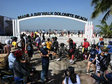 Pemandangan orang-orang yang berkumpul di Manila baywalk dolomite beach di sepanjang boulevard Roxas, kota Manila, Filipina pada Minggu (17/10/2021). Sehari sebelumnya, pihak berwenang melonggarkan pembatasan karantina di ibu kota negara itu. (Ted ALJIBE / AFP)