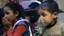Anak-anak menghirup oksigen setelah diduga terkena serangan senjata kimia di Kota Douma, dekat Damaskus, Suriah, Minggu (8/4). Douma merupakan kota yang dikuasai oleh oposisi. (Syrian Civil Defense White Helmets via AP)
