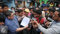 Kuasa Hukum Daeng Azis, Razman Nasution memperlihatkan surat pemberitahuan dari Pemprov DKI Jakarta yang tertempel di salah satu rumah di kawasan Kalijodo, Jakarta, Selasa (16/2). (Liputan6.com/Gempur M Surya)