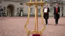 Senior footman Olivia Smith dan Heather McDonald saat akan memajang pengumuman kelahiran bayi baru kerajaan di halaman depan Istana Buckingham, London, Inggris, Senin (23/4). Anak ketiga Kate Middleton berjenis kelamin laki-laki. (Pool Photo via AP)