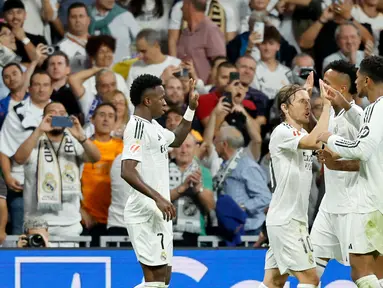 Penyerang Real Madrid, Vinicius Junior (kiri) merayakan gol kedua timnya saat pertandingan Liga Spanyol melawan Villarreal CF di stadion Santiago Bernabeu, Madrid pada Sabtu 5 Oktober 2024 atau Minggu (6/10/2024) dini hari WIB. (OSCAR DEL POZO/AFP)