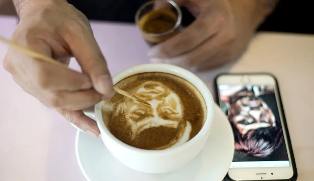 Zach Yonzon saat melukis Manny Pacquiao (Filipina) pada busa kopi susu latte di Manila, Filipina, Kamis (23/4/2015). Floyd Mayweather Jr dan Manny Pacquiao akan bertarung di MGM Grand Arena, Las Vegas, AS pada 2 Mei mendatang. (AFP PHOTO/Noel Celis)