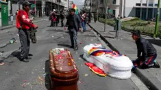 Peti mati berisi jenazah orang yang tewas dalam bentrokan antara pasukan keamanan dengan pendukung mantan Presiden Evo Morales tergeletak di tengah jalan setelah polisi meluncurkan gas air mata pada prosesi pemakaman besar-besaran di El Paz, Bolivia, Kamis (21/11/2019). (AP Photo/Juan Karita)