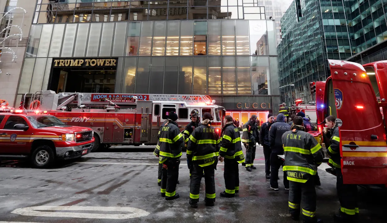 Kendaraan dan para petugas pemadam berada di lokasi kebakaran di Fifth Avenue, depan Trump Tower, di New York, Senin (8/1). Kebakaran yang mengakibatkan dua orang luka-luka tersebut berasal dari pendingin di bagian atas gedung. (AP Photo/Richard Drew)