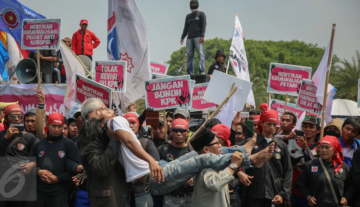 Massa Gerakan Masyarakat Sipil Melawan Kriminalisasi melakukan aksi teaterikal di depan Istana Negara, Jakarta, Kamis (15/10). Mereka menuntut pemerintah segera membatalkan revisi UU KPK dan penetapan RPP tentang pengupahan. (Liputan6.com/Faizal Fanani)