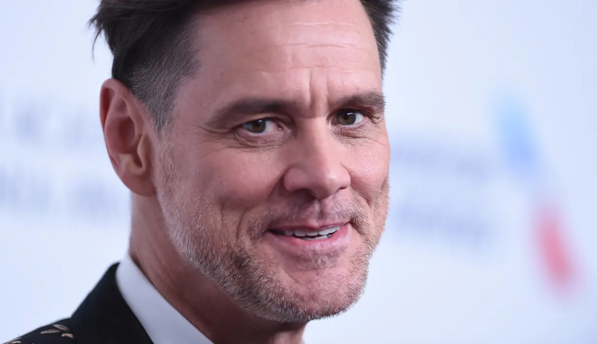 Ekspresi Jim Carrey saat tiba menghadiri acara BAFTA Los Angeles Britannia Awards 2018 di Beverly Hilton di Beverly Hills, California (26/10). Jim Carrey tampil keren mengenakan jas bermotif kembang. (AFP Photo/Valerie Macon)
