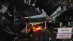 Warga Palestina duduk di tenda yang didirikan di atas reruntuhan bangunan yang hancur dalam serangan udara Israel di Kota Gaza (24/5/2021). Menyusul gencatan senjata yang dicapai setelah perang 11 hari antara Israel dan Hamas, Warga Palestina mendirikan tenda di reruntuhan. (AFP/Mohamed Abed)