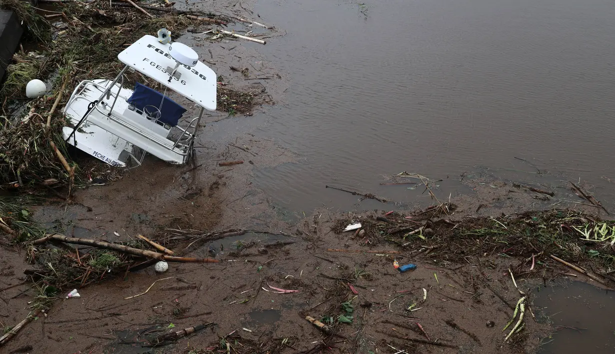 Sebuah foto menunjukkan kerusakan dan sebuah kapal yang karam di pinggir laut setelah lewatnya topan Belal di Saint-Paul, di pulau La Reunion, Prancis, di Samudra Hindia pada 15 Januari 2024. (Richard BOUHET/AFP)