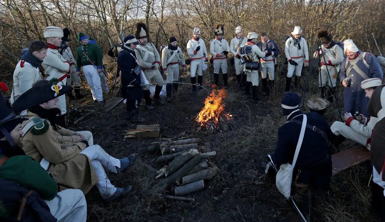 Rombongan para penggemar sejarah yang mengenakan pakaian tentara tahun 1800-an beristirahat saat peringatan mengenang kembali pertempuran Austerlitz di dekat desa Moravian selatan Herspice, Republik Ceko (2/11). (Reuters/David W Cerny)