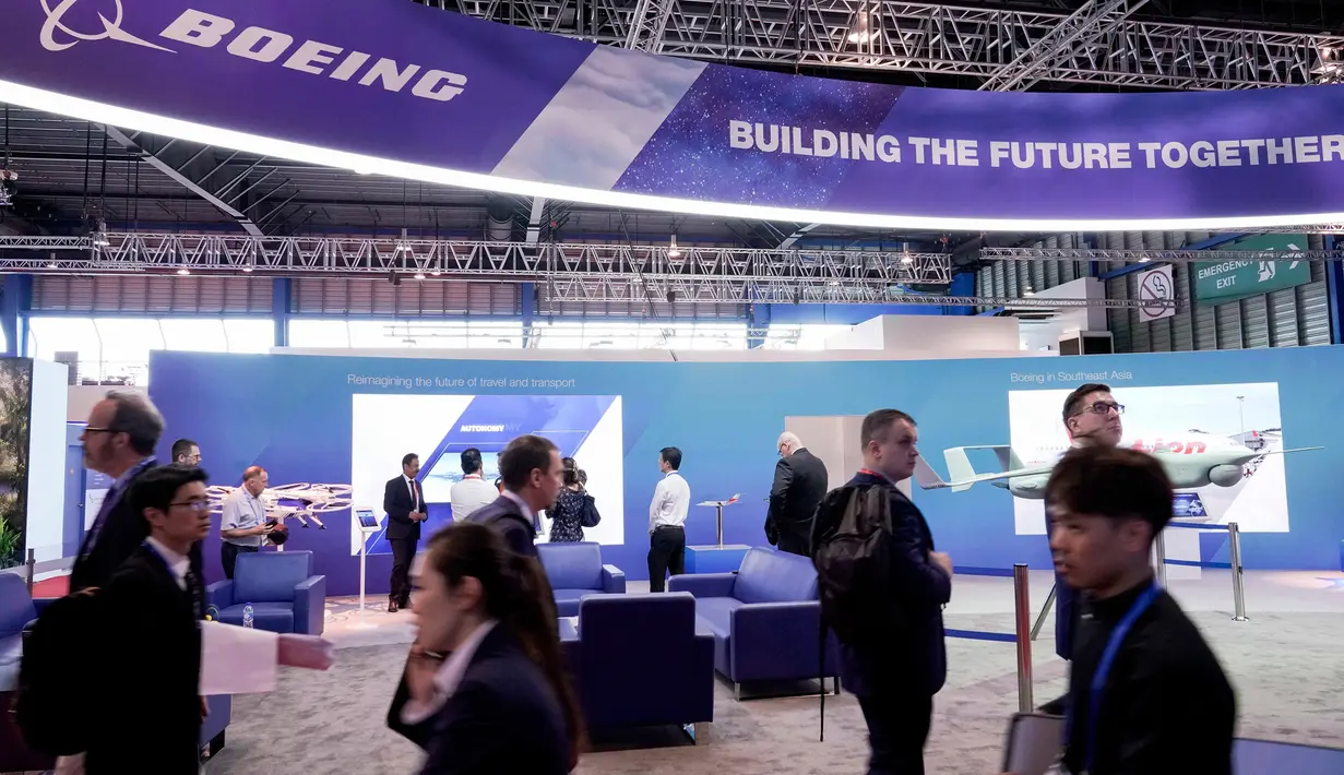 Pengunjung berjalan melewati stan Boeing pada pembukaan Singapore Airshow di Singapura, Selasa (11/2/2020). Pameran dirgantara terbesar di Asia tersebut dibayangi wabah virus korona, yang memaksa puluhan perusahaan dunia absen dalam perhelatan besar itu. (AP/Danial Hakim)
