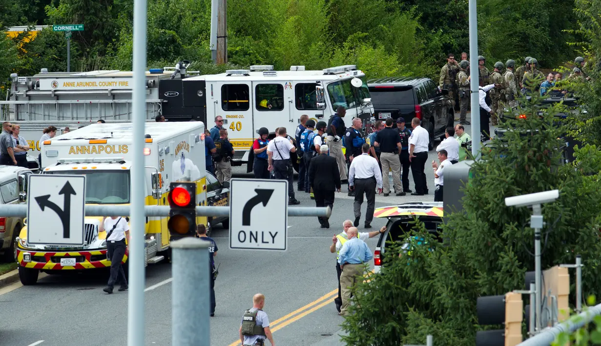 Pihak berwenang berada di pintu masuk gedung setelah penembakan di kantor surat kabar Capital Gazette di Annapolis, AS, Kamis (28/6). Polisi menemukan barang yang diduga alat peledak dan sekitar 170 orang telah dievakuasi dari gedung (AP/Jose Luis Magana)