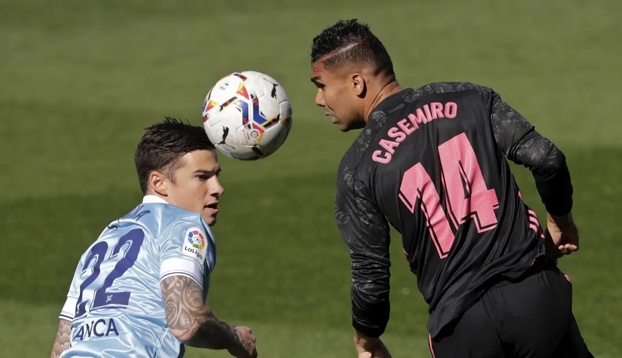 Gelandang Real Madrid, Casemiro (kanan) menyundul bola dari ancaman striker Celta Vigo, Santi Mina dalam laga lanjutan Liga Spanyol 2020/2021 pekan ke-28 di Balaidos Stadium, Sabtu (20/3/2021). Real Madrid menang 3-1 atas Celta Vigo. (AP/Lalo R. Villar)