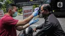 Petugas memeriksa suhu tubuh seorang pria saat akan memasuki Kompleks Istana Kepresidenan, Jakarta, Selasa (3/3/2020). Istana Kepresidenan memperketat pemeriksaan terhadap tamu, ASN, dan pejabat negara untuk mencegah penyebaran virus corona (COVID-19). (Liputan6.com/Faizal Fanani)