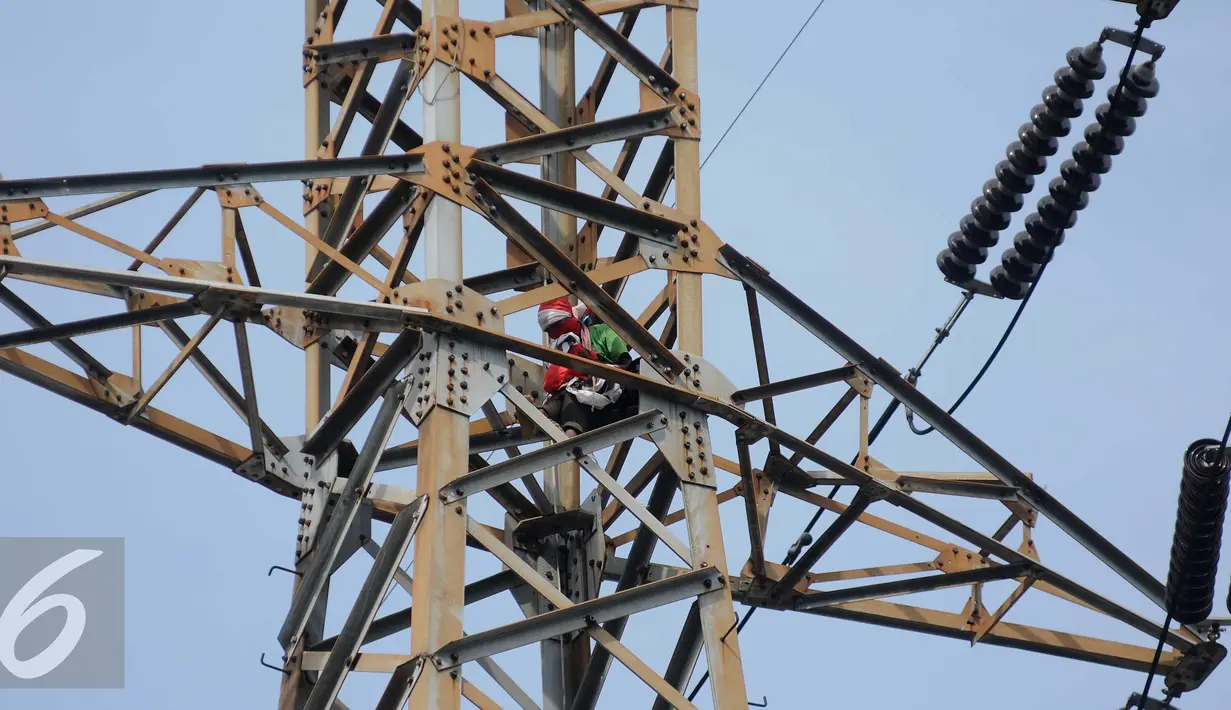 Seorang pria berada di atas menara sutet di kawasan Pasar Senen, Jakarta, Selasa (27/9). Pria nekat tersebut berencana memasang bendera merah putih dengan sebuah kalimat berisi permintaan untuk menghukum oknum Dandim. (Liputan6.com/Gempur M Surya)