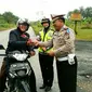 Sebagai imbalan bagi warga yang lengkap selama berkendara, jajaran Polda Riau di Siak dan Pekanbaru, memberikan hadiah berupa mawar dan jam dinding. (Liputan6.com/M Syukur)