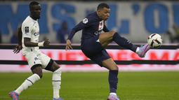 Penyerang Paris Saint-Germain (PSG) Kylian Mbappe mencetak gol ketiga timnya ke gawang dalam laga berebut bola dengan bek Marseille Eric Bailly dalam laga pekan ke-25 Liga Prancis 2022-2023, di Stadion Velodrome pada Senin (27/2/2023) dini hari WIB. Kylian Mbappe mencapai 200 gol dalam 245 penampilan. (AP Photo/Daniel Cole)