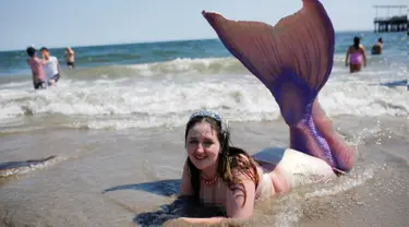 Peserta berpakaian seperti putri duyung sambil berenang di pantai saat mengikuti parade Mermaid, Brooklyn , New York , (18/6). Acara yang digelar setiap tahun ini menarik jumlah peserta dan wisatawan di Brooklyn , New York. (REUTERS / Eduardo Munoz)