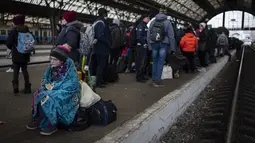 Penumpang menunggu di peron stasiun kereta api Lviv, di Lviv, Ukraina barat pada Minggu, 27 Februari 2022. Dengan mobil, kereta api, dan berjalan kaki, puluhan ribu pengungsi Ukraina mencari keselamatan di negara-negara tetangga Ukraina saat invasi Rusia. (AP Photo/Bernat Armangue)