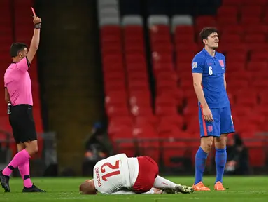 Bek Inggris Harry Maguire (kanan) mendapat kartu merah setelah menjegal penyerang Denmark, Kasper Dolberg (tengah) dalam lanjutan pertandingan UEFA Nations League grup A2 di stadion Wembley di London (14/10/2020). Inggris takluk atas Denmark 0-1. (AFP/Pool/Daniel Leal-Olivas)