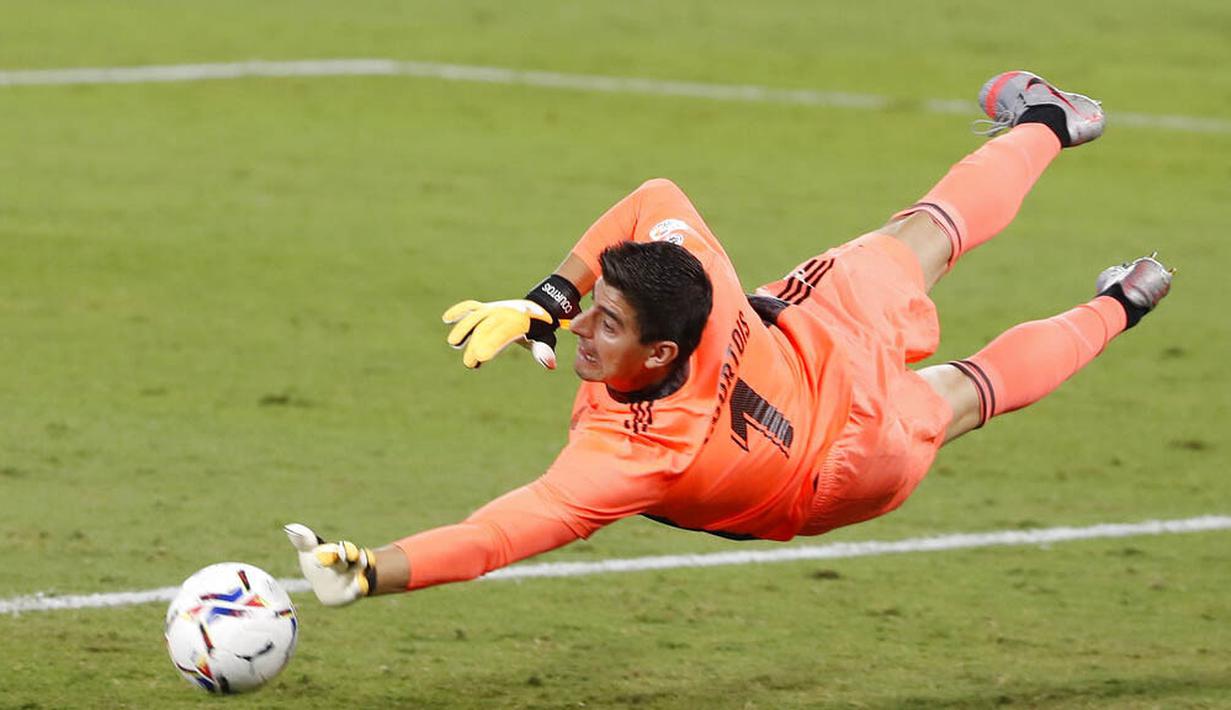Kiper Real Madrid, Thibaut Courtois, melakukan penyelamatan saat melawan Real Betis pada laga La Liga di Stadion Benito Villamarin, Minggu (27/9/2020). Real Madrid menang dengan skor 3-2. (AP Photo/Angel Fernandez)