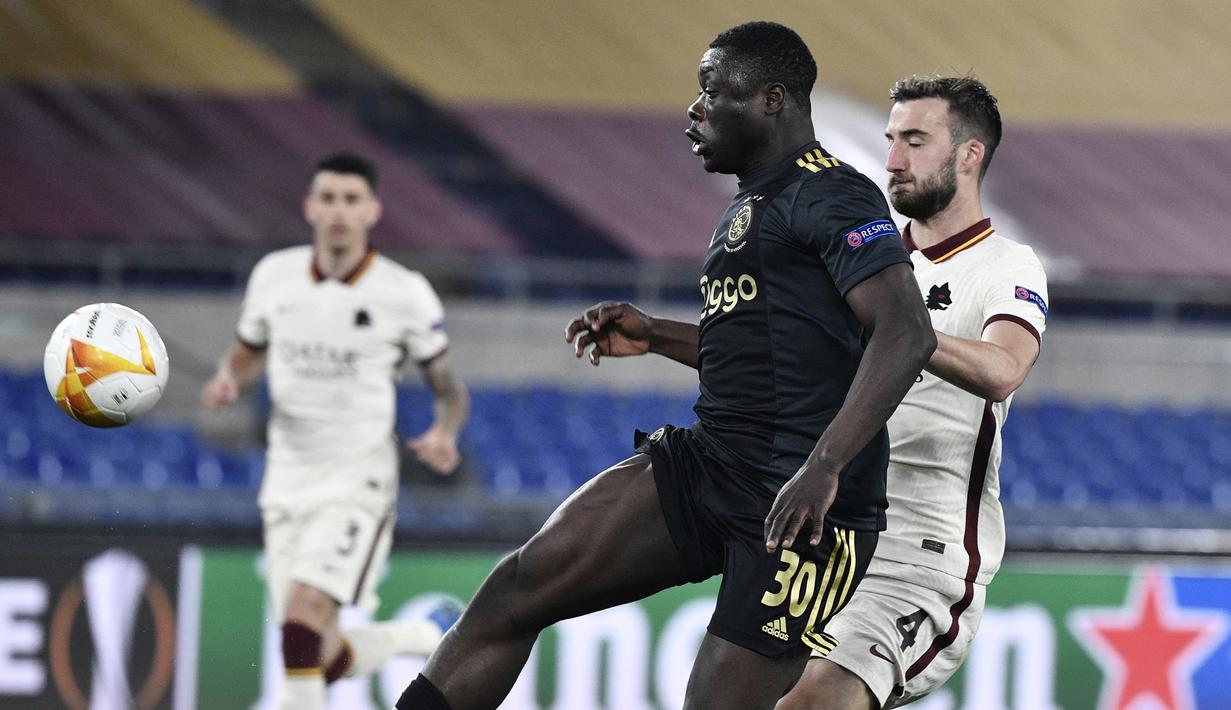 Striker Ajax Amsterdam, Brian Brobbey (kiri) melepaskan tendangan yang berbuah gol ke gawang AS Roma dalam laga leg kedua perempatfinal Liga Europa 2020/2021 di Olimpico Stadium, Roma, Kamis (15/4/2021). Ajax bermain imbang 1-1 dengan AS Roma. (AFP/Filippo Monteforte)