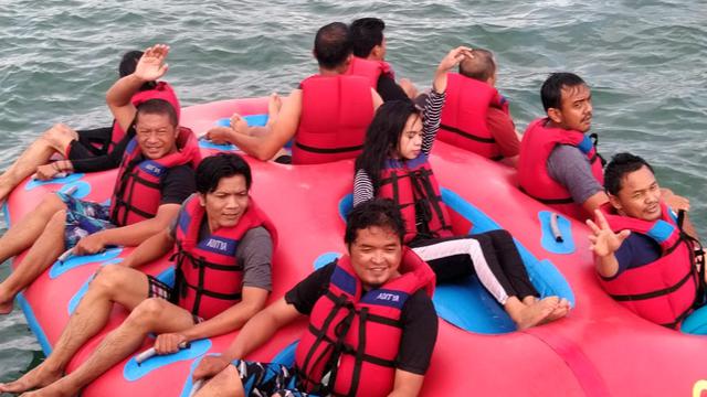 Beberapa pengunjung tengah menikmati fasilitas bermain di spot wisata air kawasan Pantai Timur Pangandaran, Jawa Barat.