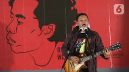Aktivis reformasi yang juga Direktur Eksekutif Amnesty Internasional Indonesia Usman Hamid membawakan lagu pada peringatan 60 tahun penyair Wiji Thukul bertajuk "Selamat Ulang Tahun Wiji Thukul, Kau Dimana?" di Galeri Nasional, Jakarta, Sabtu (26/8/2023). (Liputan6.com/Faizal Fanani)
