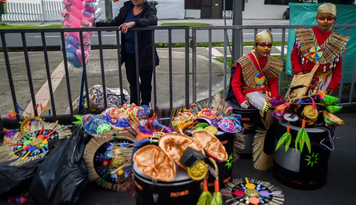 Peserta mengenakan kostum dan riasan beristirahat di sela-sela acara parade Canto a la Tierra di Pasto, Kolombia (3/1). Parade ini juga merupakan bagian dari Warisan Budaya Takbenda UNESCO pada tahun 2009. (AFP Photo/Luis Robayo)