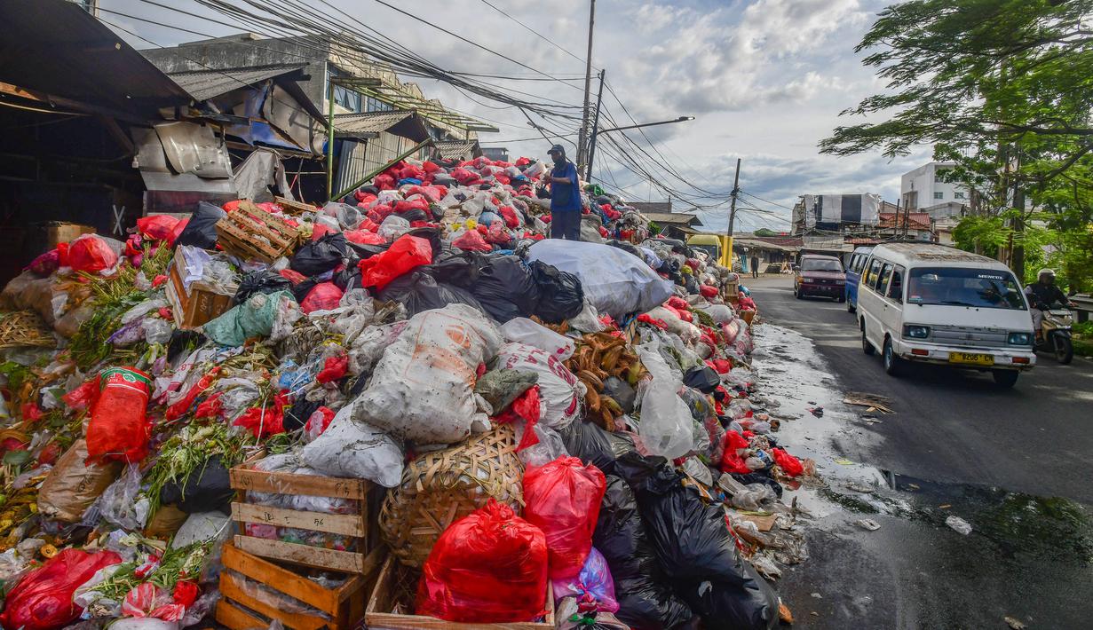 Petugas mengatur tumpukan sampah pada pinggir jalan di kawasan Pasar Manggis, Ciputat, Tangerang Selatan, Senin (15/12/2025). Sudah lebih dari sepekan wilayah Tangerang Selatan (Tangsel) mengalami krisis lokasi pembuangan akhir sampah. (merdeka.com/Arie Basuki)