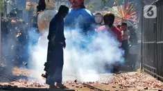 Warga memegang petasan besar yang dibakar saat kegiatan pawai jelang Ramadan di kawasan Pondok Cabe Ilir, Tangerang Selatan, Banten, Minggu (27/3/2022). Kegiatan yang diselenggarakan Sanggar Seni Rumah Baba ini diikuti puluhan warga. (merdeka.com/Arie Basuki)