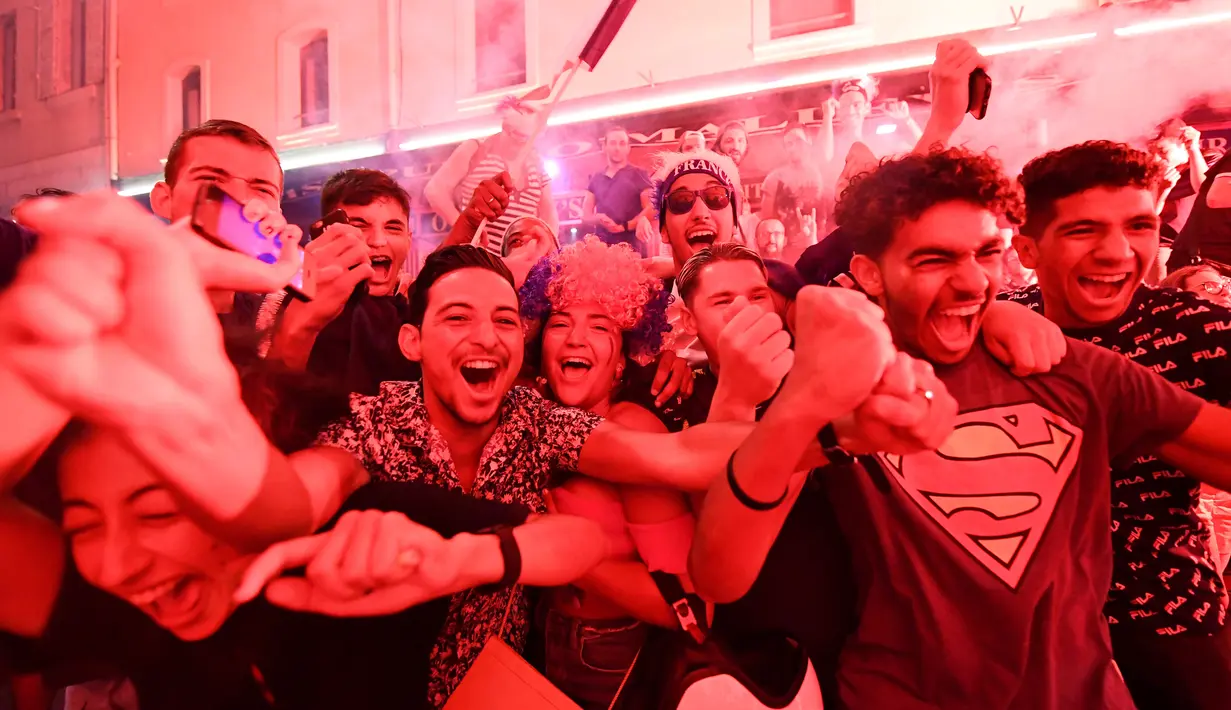 Luapan kegembiraan warga saat peluit akhir pertandingan antara Prancis dengan Belgia pada semifinal Piala Dunia 2018, Marseille, Prancis, Selasa (10/7). Prancis menaklukkan Belgia dan maju ke babak final. (BORIS HORVAT/AFP)