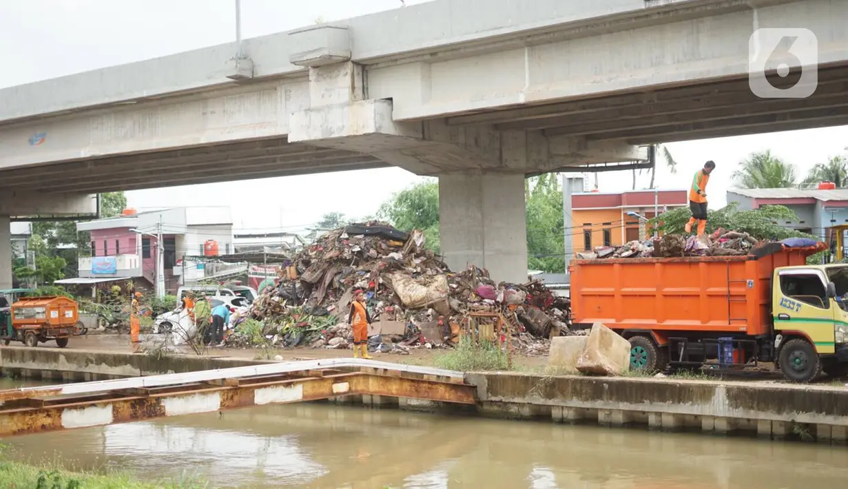 Petugas mengangkut sampah sisa banjir yang menumpuk di kawasan Cipinang Melayu, Jakarta, Senin (6/1/2020). Banjir yang menggenangi Jakarta dan sekitarnya sejak 1 Januari 2020 lalu menyisakan tumpukan sampah di sejumlah titik. (Liputan6.com/Immanuel Antonius)