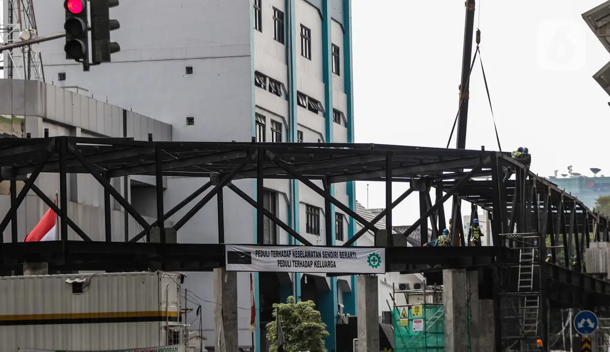 Pekerja menyelesaikan jembatan layang integrasi antara Stasiun MRT ASEAN dengan Halte Transjakarta CSW koridor 13, Jakarta, Rabu (8/1/2020). Jembatan layang ini nantinya akan memudahkan penumpang untuk mengakses salah satu moda transportasi baik MRT atau Transjakarta. (Liputan6.com/Faizal Fanani)