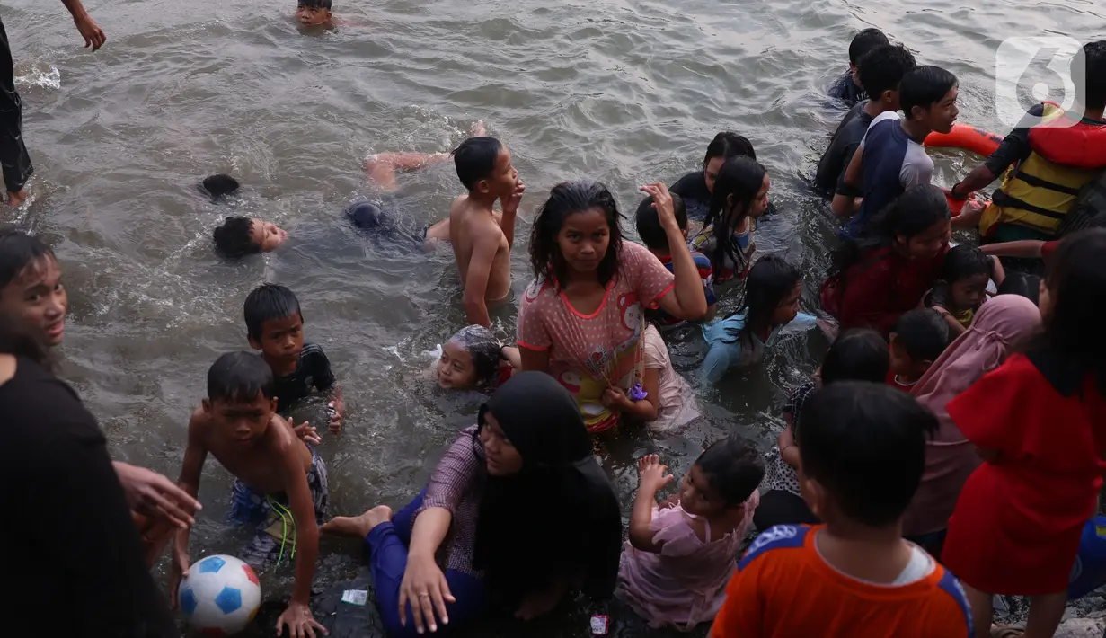 Warga  saat mengikuti keramas bersama di bantaran sungai Cisadane di kawasan Babakan, Kota Tangerang, Jumat (1/4/2022). Keramas bersama merupakan tradisi warga yang berada dikawasan tersebur sebagai simbol membersihkan diri untuk menyambut bulan Ramadhan. (Liputan6.com/Angga Yuniar)