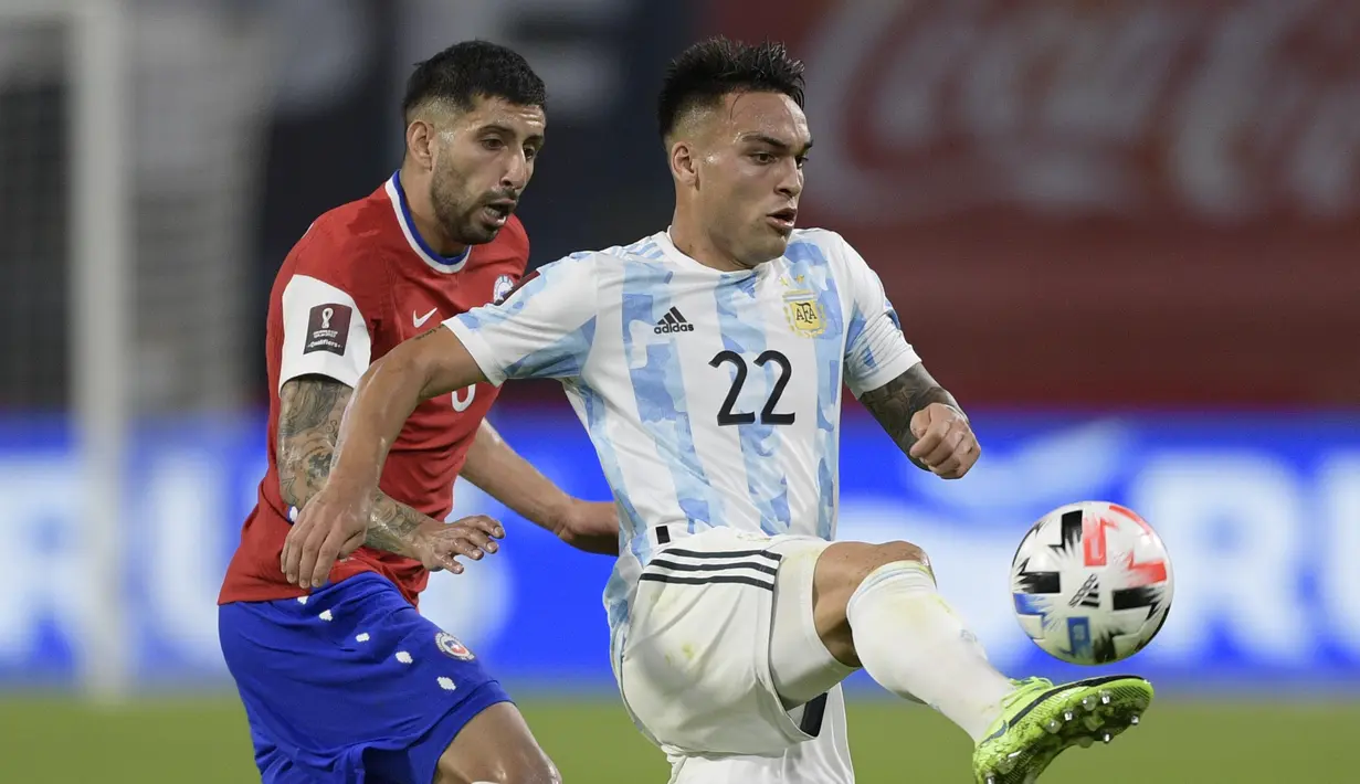 Penyerang Argentina, Lautaro Martinez mengontrol bola dari kawalan pemain Chile, Guiilermo Maripan dalam laga Kualifikasi Piala Dunia 2022 zona CONMEBOL, di Santiago del Estero, Argentina, Jumat (4/6/2021). Hasil ini membuat Argentina tetap di posisi kedua dengan 11 poin. (Juan Mabromata, Pool via A