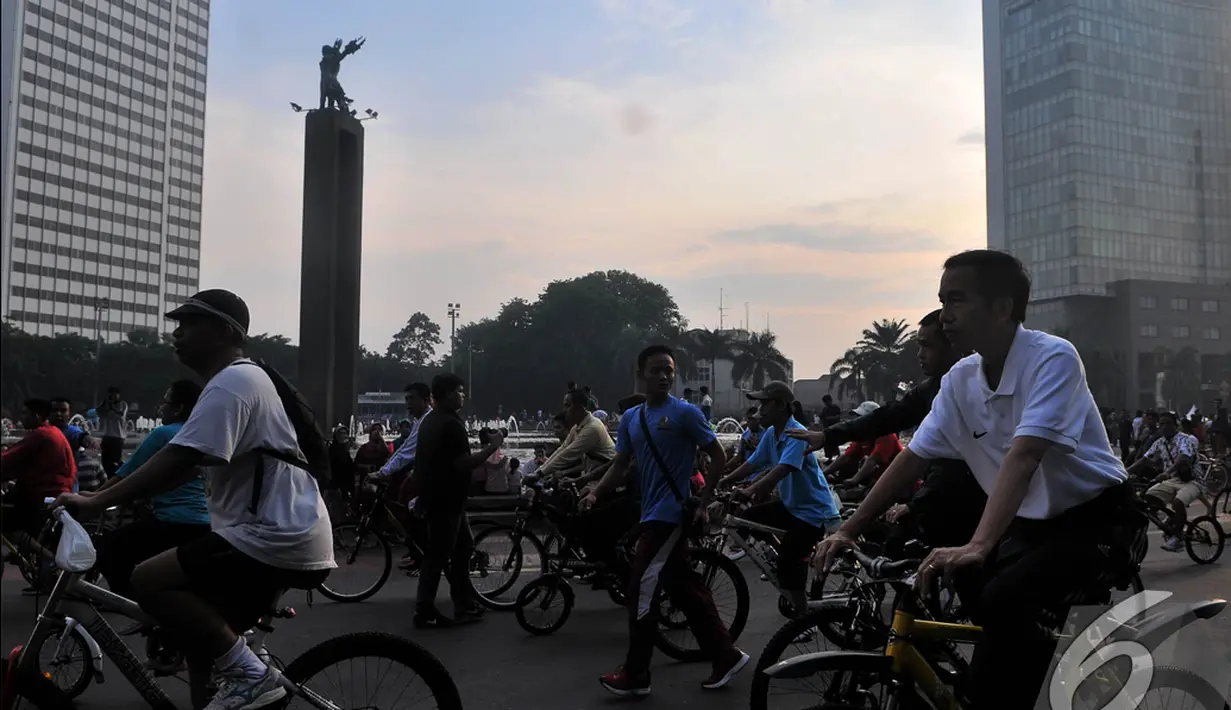  Presiden  Joko Widodo (Jokowi) saat bersepeda di kawasan Car Free Day melintasi Bundaran HI, Jakarta, Minggu (23/11/2014) (Liputan6.com/Herman zakharia)