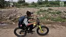 Anak sekolah melintas di pinggir Kali Pisang Batu yang dipenuhi sampah, Tarumajaya, Bekasi, Jawa Barat, Rabu (9/1). Warga tetap beraktivitas meski bau tak sedap menghantui mereka akibat tumpukan sampah di kali tersebut. (Merdeka.com/Iqbal S. Nugroho)