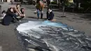 Sejumlah warga berpose untuk berfoto di depan karya ilusi optik 3-D yang bergambar kota Aleppo yang hancur akibat perang di kampus Universitas Meiji di Tokyo, Jepang (18/11). (AFP/Toshifumi Kitamura
