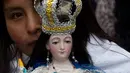 Sebuah patung menggambarkan Our Lady of Socavon dibawa saat prosesi untuk menghormati santo pelindung mereka, di Oruro, Bolivia (1/3). Seniman tersebut menggambarkan santo pelindung mengenakan celana dalam merah dan stoking hitam. (AP Photo/Juan Karita)