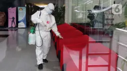 Petugas menyemprotkan cairan disinfektan di bangku tamu, Gedung Merah Putih KPK, Jakarta, Kamis (24/6/2021). Setelah 36 pegawainya terkonfirmasi positif Covid-19, KPK melakukan pembatasan kerja hingga Jumat (25/6) sebagai langkah tanggap pencegahan penyebaran. (Liputan6.com/Helmi Fithriansyah)