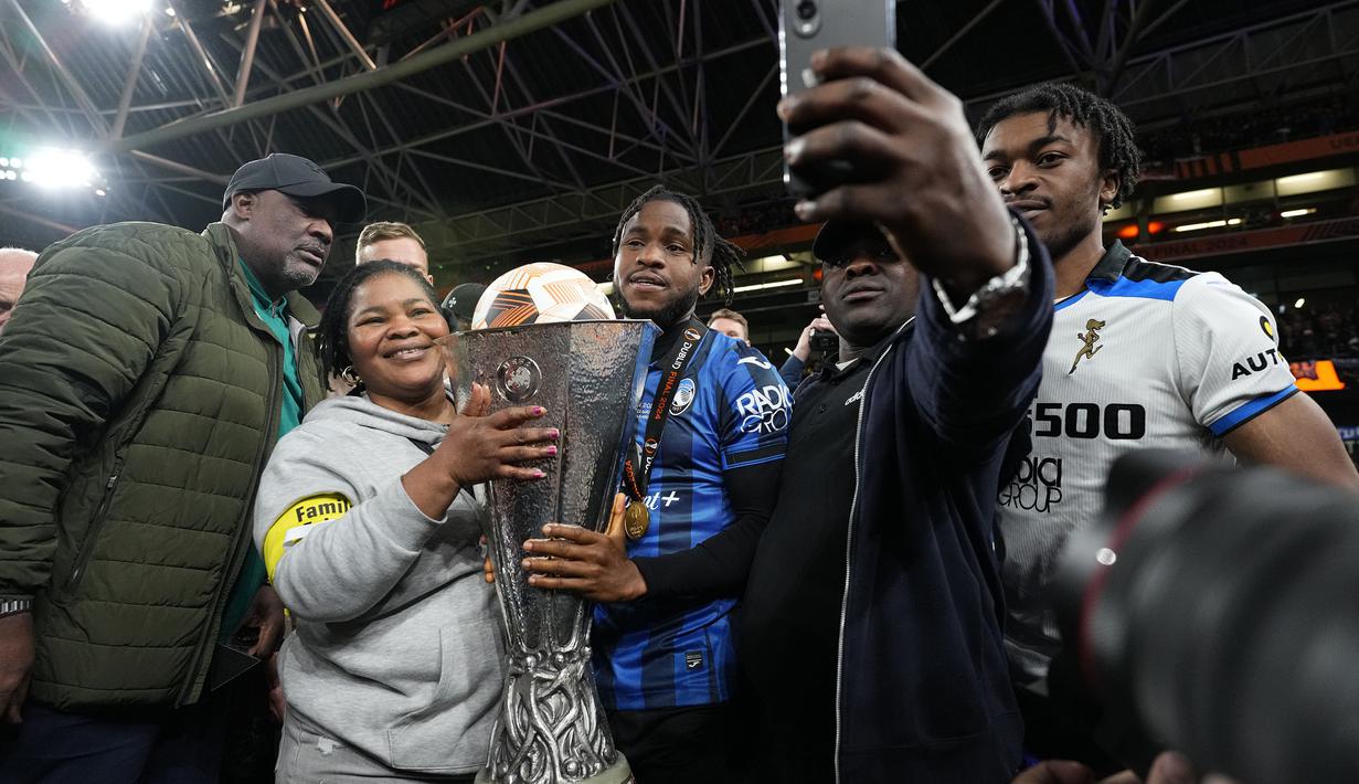 Pemain Atalanta, Ademola Lookman (tengah) bersama keluarganya melakukan swafoto saat merayakan gelar juara Liga Europa 2023/2024 setelah mengalahkan Bayer Leverkusen di laga final yang berlangsung di Dublin Arena, Irlandia, Kamis (23/05/2024) dini hari WIB. (AP Photo/Kirsty Wigglesworth)