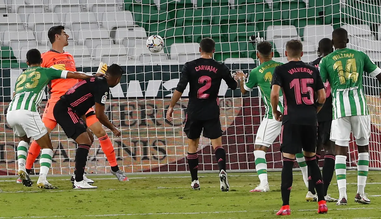 Pemain Real Betis Aissa Mandi ( kiri) mengejar bola untuk mencetak gol ke gawang Real Madrid pada pertandingan La Liga di Stadion Benito Villamarin, Seville, Spanyol, Sabtu (26/9/2020). Real Madrid mengalahkan Real Betis 3-2. (AP Photo/Angel Fernandez)