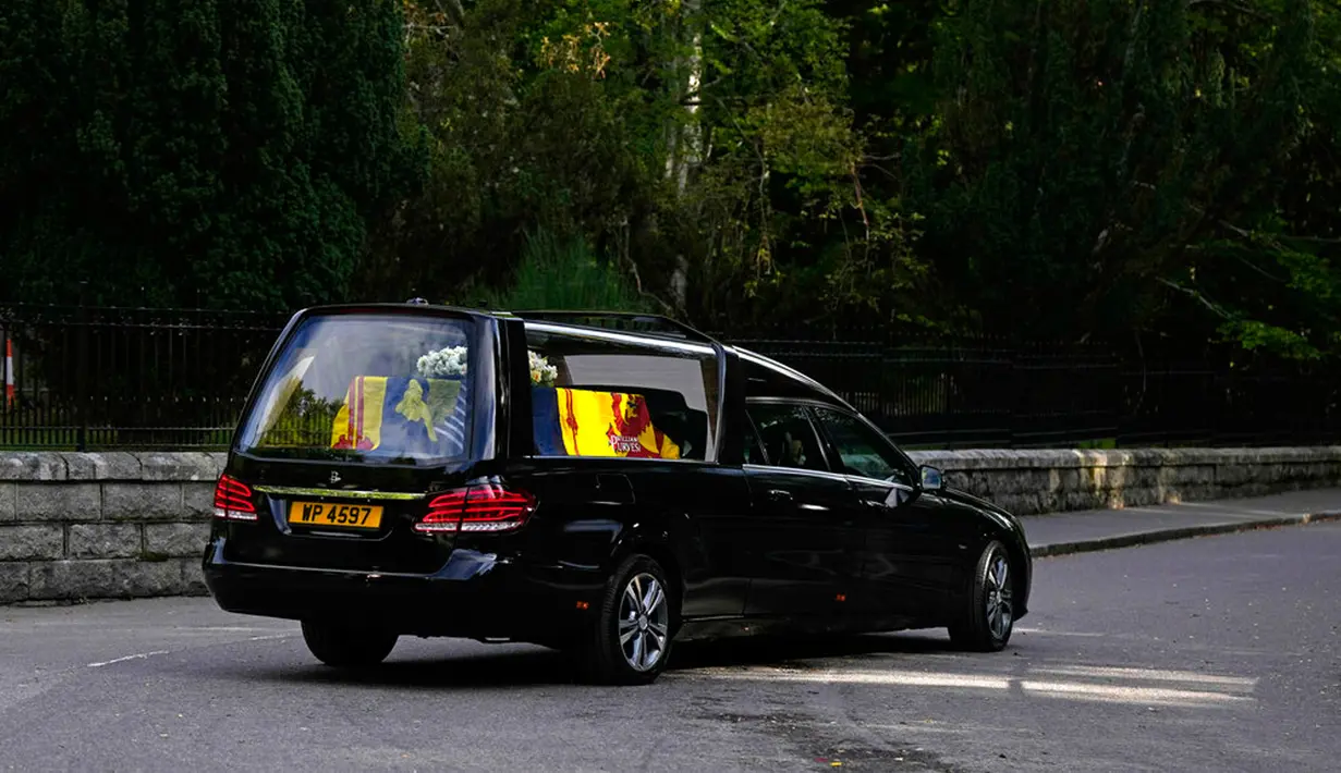 Mobil yang membawa peti berisi jenazah Ratu Elizabeth II meninggalkan Kastil Balmoral di Skotlandia, Minggu (11/9/2022). Jenazah Ratu Elizabeth II diberangkatkan dari Kastil Balmoral ke Istana Holyroodhouse di Edinburgh sebelum nantinya akan dipindahkan ke London. (AP Photo/Alastair Grant)