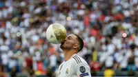 Pemain baru Real Madrid, Eden Hazard mencium bola saat diperkenalkan di stadion Santiago Bernabeu di Madrid, Spanyol (13/6/2019). Real Madrid mengumumkan telahresmi membeli pemain asal Belgia tersebut dari klub Inggris, Chelsea. (AP Photo/Manu Fernandez)