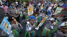 Puluhan polisi cilik berjoged saat melakukan kampanye keselamatan berkendara di kawasan Bundaran HI, Jakarta, Minggu (12/3). Kampanye tersebut diadakan guna mengajak pengguna jalan agar tertib dalam berlalu lintas. (Liputan6.com/Immanuel Antonius)