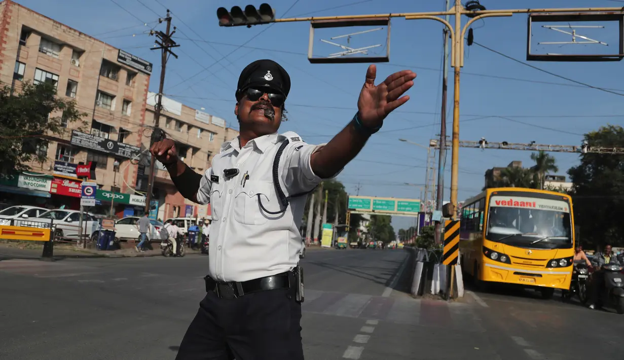 Polisi lalu lintas India, Ranjeet Singh arus kendaraan bermotor di persimpangan yang sibuk di Indore pada 18 November 2019. Singh yang memiliki kumis ala Freddie Mercury ini mengatur lalu lintas sambil menari juga bergerak menghindari bajaj dan truk yang melintas. (AP/Aijaz Rahi)